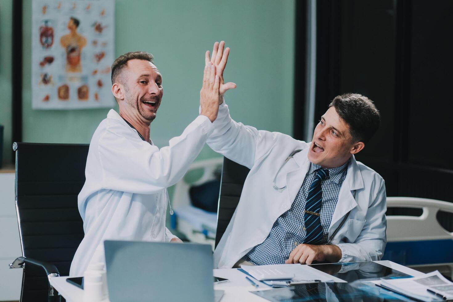 Smiling young male clinician shake hands with happy teammate appreciate for assistance on surgery show support respect on team council. Two doctors partners handshaking making deal reaching agreement photo