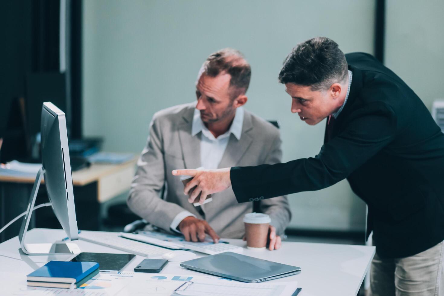 Two businessmen working together Analyze financial reports with charts and graphs while using the calculator to calculate budget, income, taxes, business growth. Startup business idea. photo