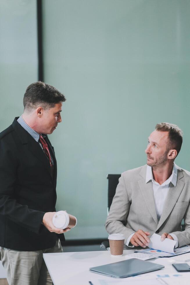 Two businessmen working together Analyze financial reports with charts and graphs while using the calculator to calculate budget, income, taxes, business growth. Startup business idea. photo