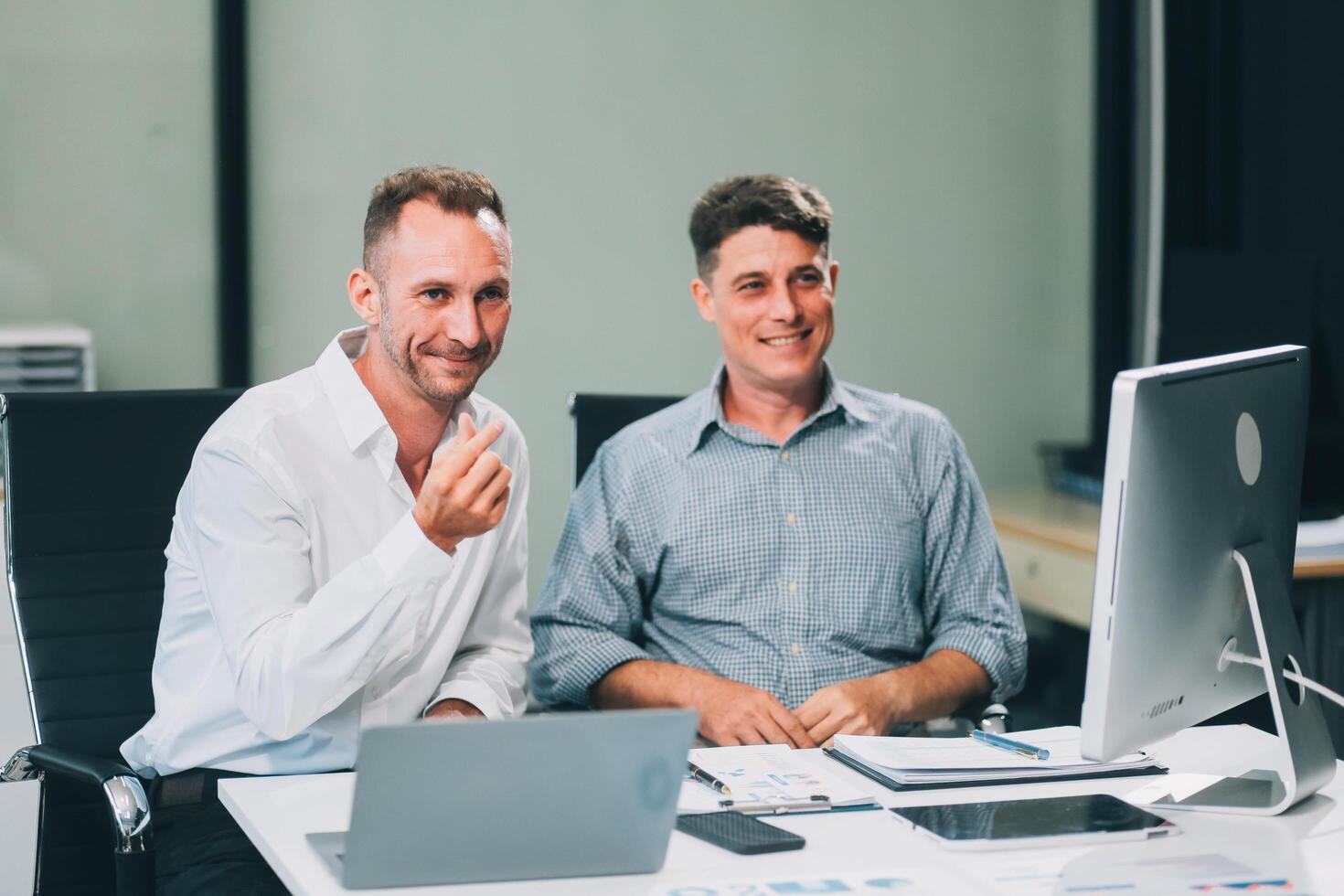 Two businessmen working together Analyze financial reports with charts and graphs while using the calculator to calculate budget, income, taxes, business growth. Startup business idea. photo