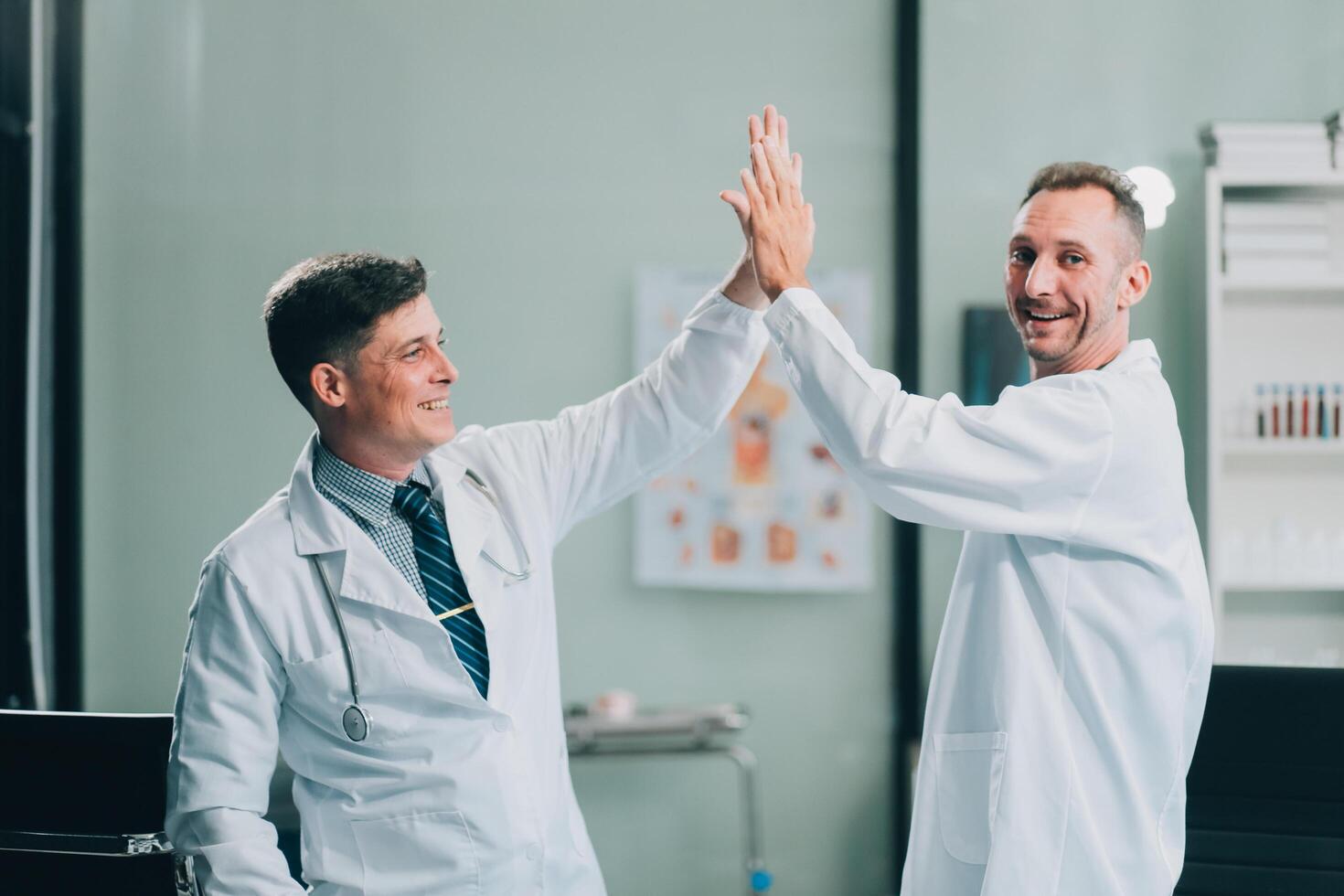 Smiling young male clinician shake hands with happy teammate appreciate for assistance on surgery show support respect on team council. Two doctors partners handshaking making deal reaching agreement photo