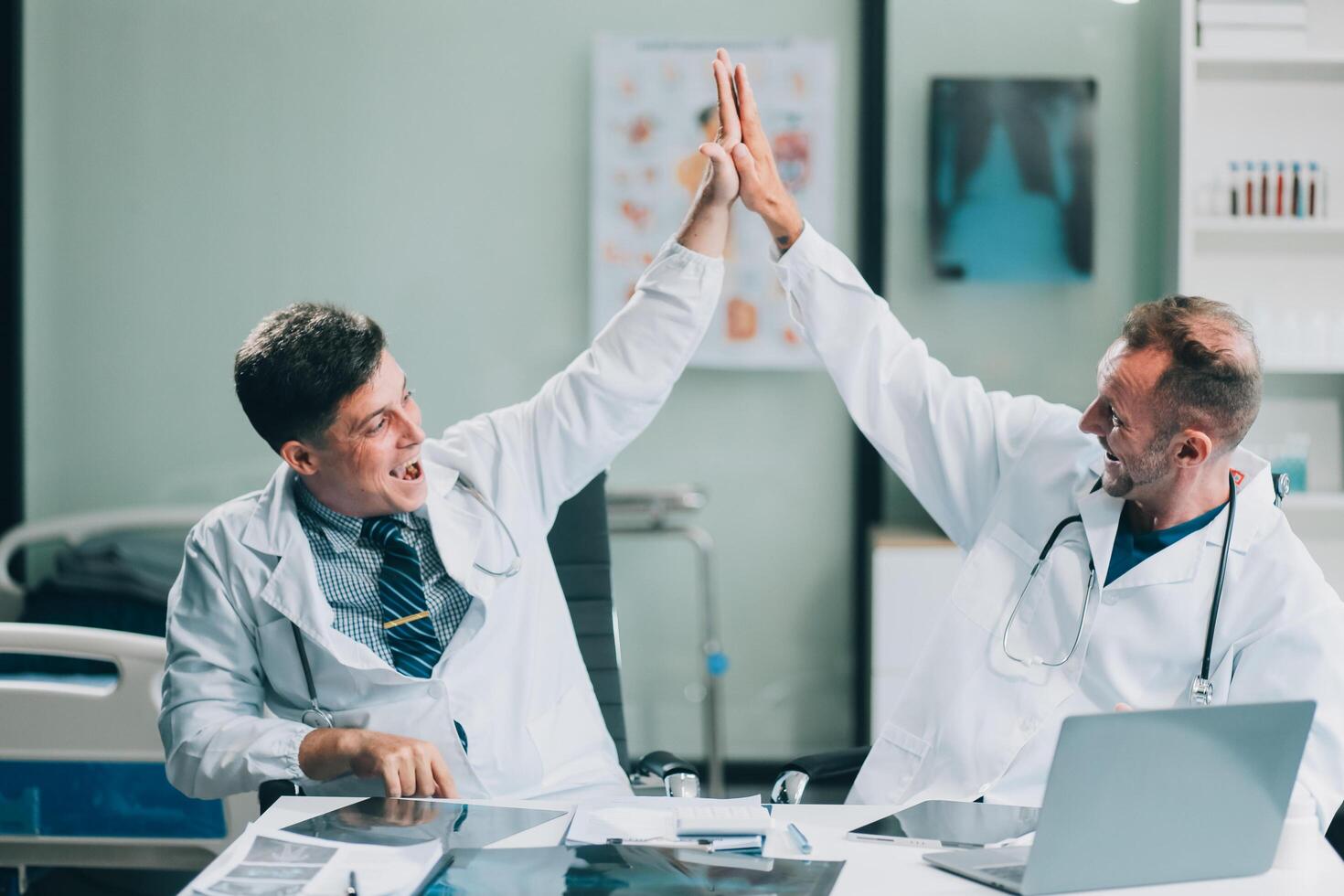 Smiling young male clinician shake hands with happy teammate appreciate for assistance on surgery show support respect on team council. Two doctors partners handshaking making deal reaching agreement photo