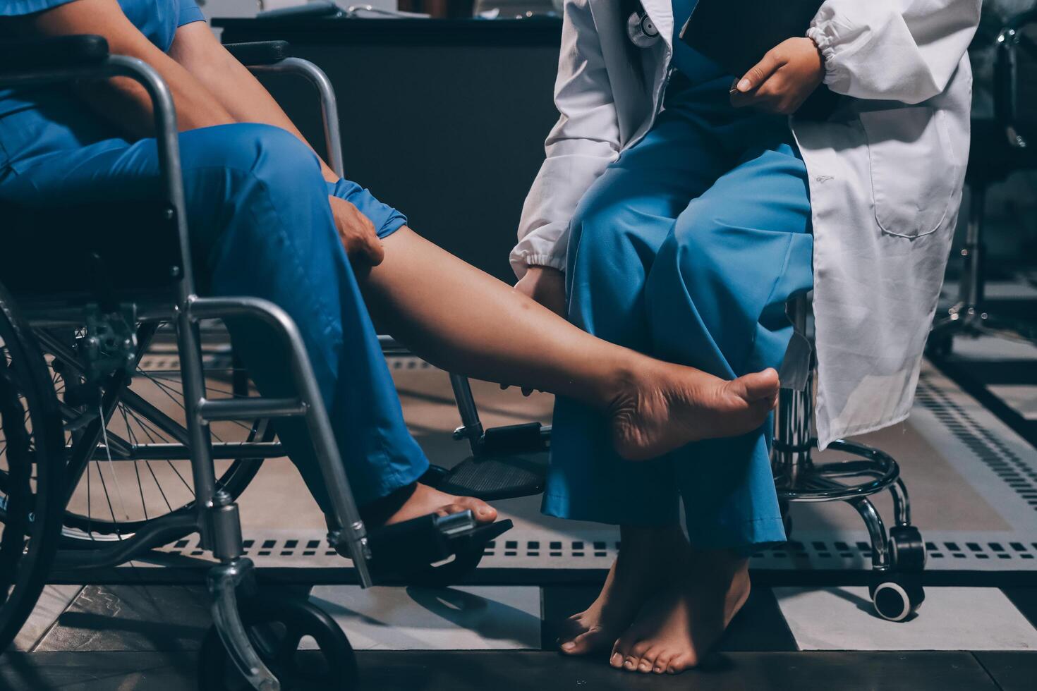 Physiotherapist nurse doing physiotherapy to rehabilitate leg of elderly female patient. photo
