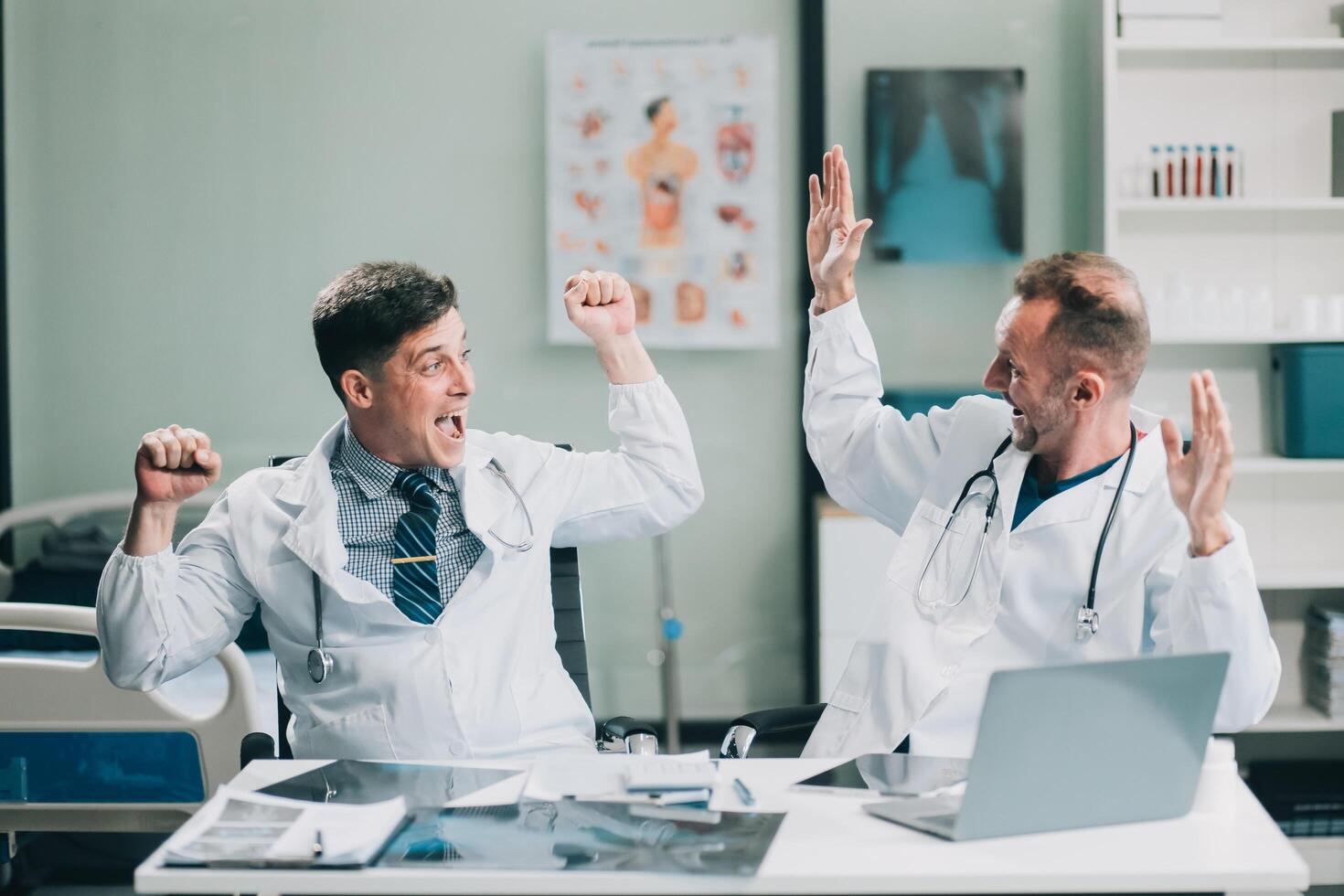 Smiling young male clinician shake hands with happy teammate appreciate for assistance on surgery show support respect on team council. Two doctors partners handshaking making deal reaching agreement photo
