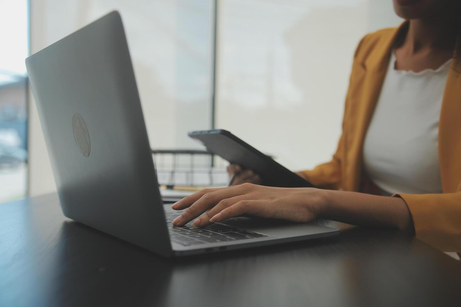Close up Business woman using calculator and laptop for do math finance on wooden desk, tax, accounting, statistics and analytical research concept photo