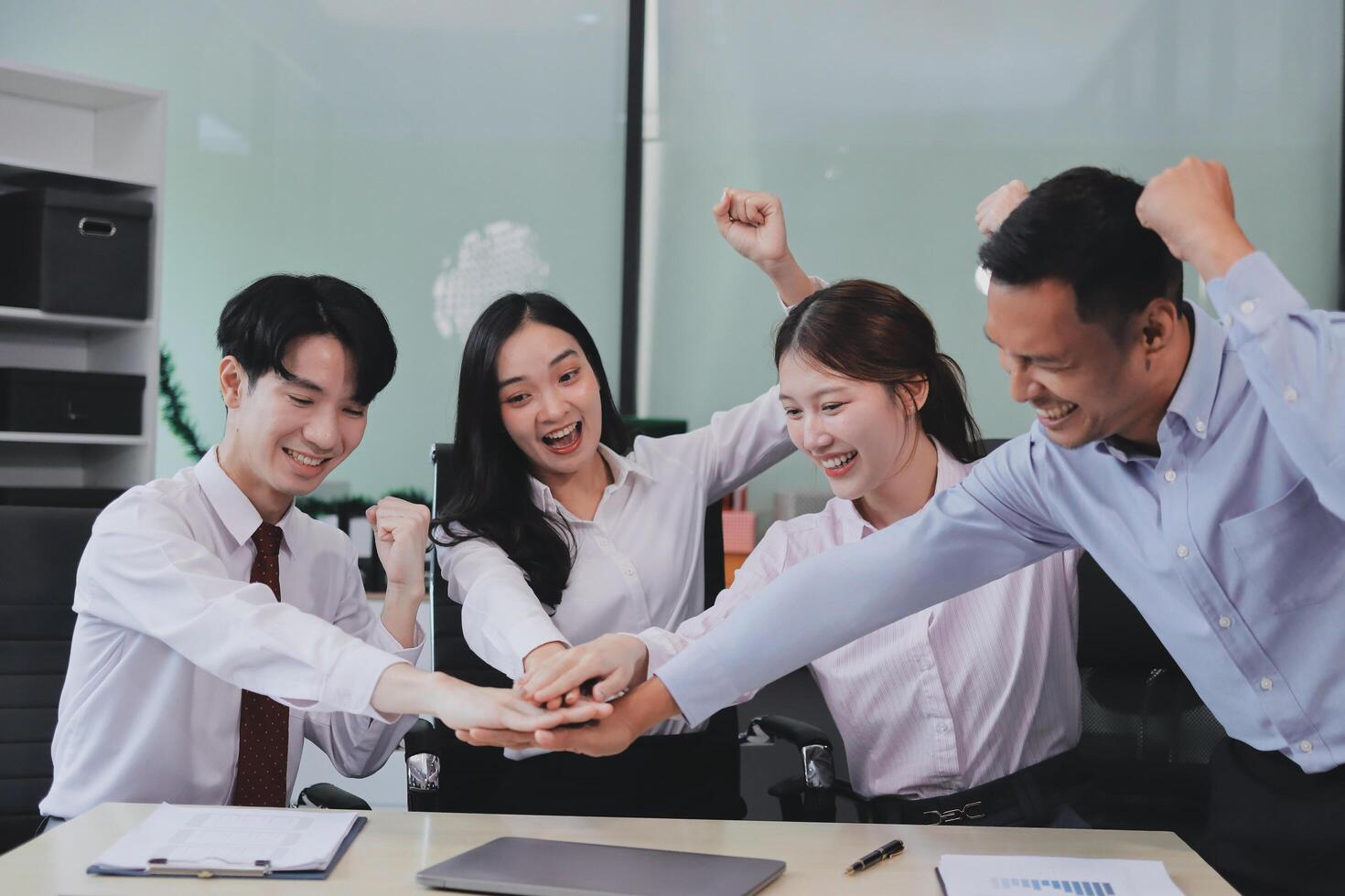 Group of business workers standing with hands together at the office photo
