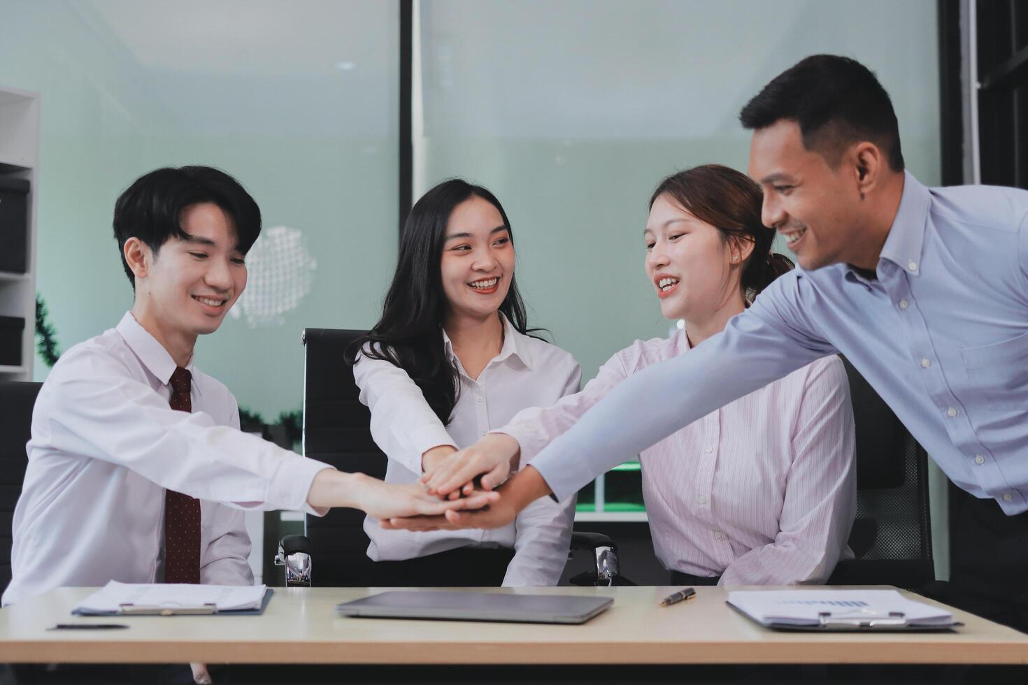 Group of business workers standing with hands together at the office photo