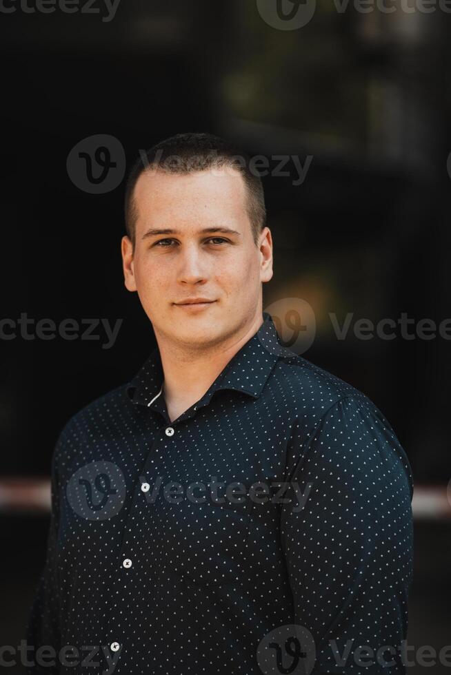 A portrait of a modern man, exuding confidence and style, against an outdoor backdrop, showcasing his charisma and fashionable demeanor. photo