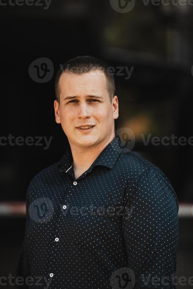 A portrait of a modern man, exuding confidence and style, against an outdoor backdrop, showcasing his charisma and fashionable demeanor. photo