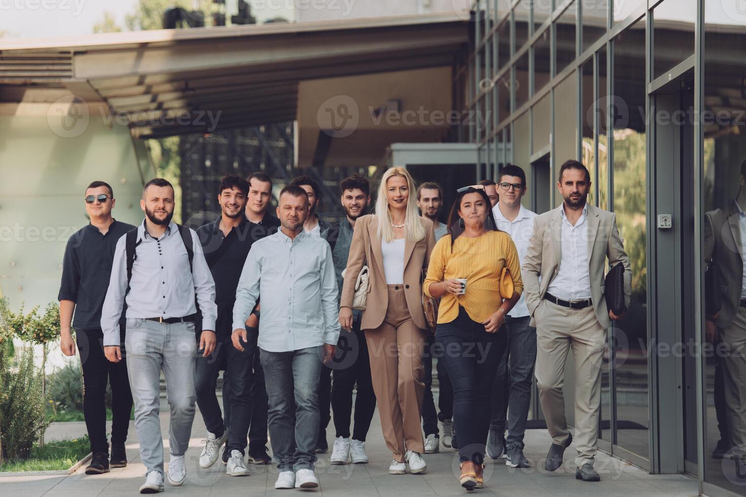 A diverse group of businessmen and colleagues walking together by their workplace, showcasing collaboration and teamwork in the company. photo