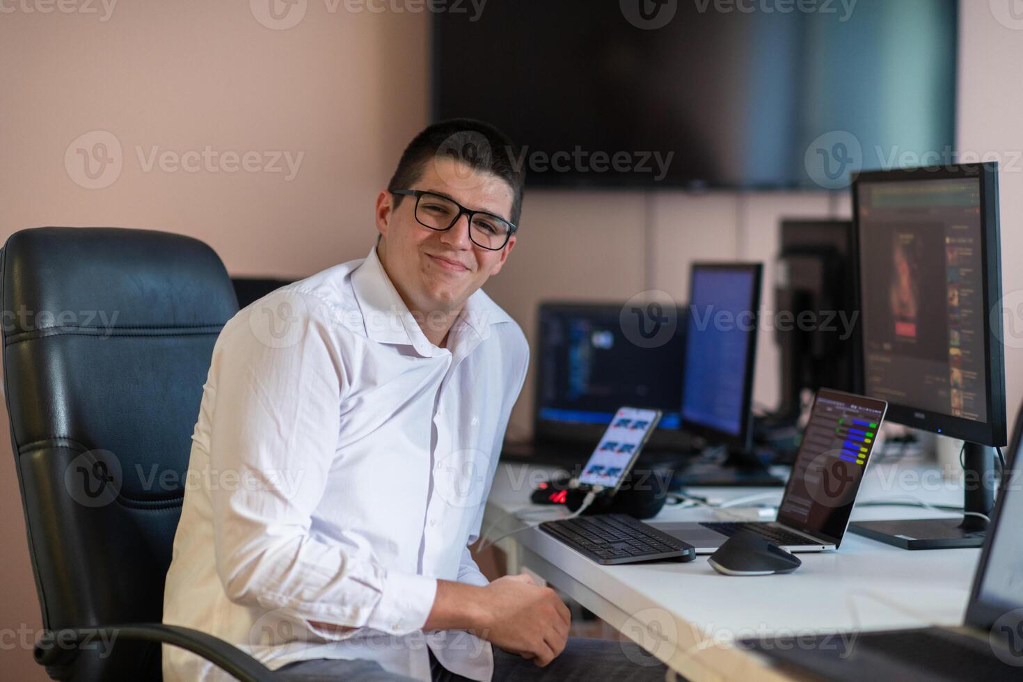 A programmer diligently testing smartphone applications while sitting in their office. photo
