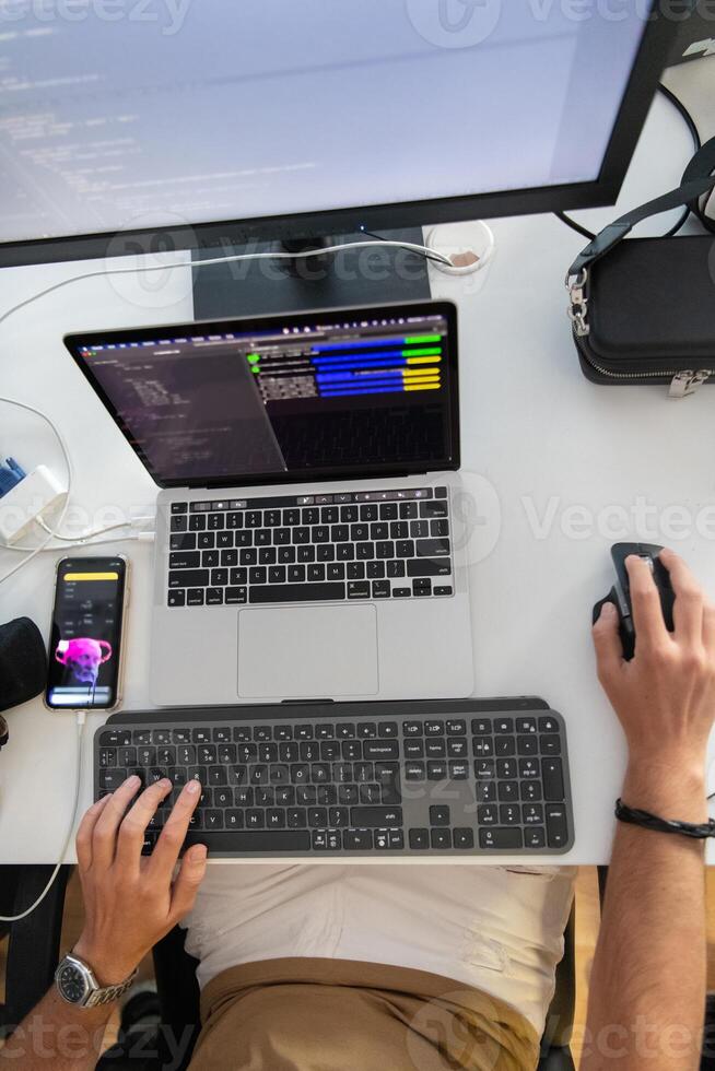 Top view of programmer diligently testing smartphone applications while sitting in their office. photo