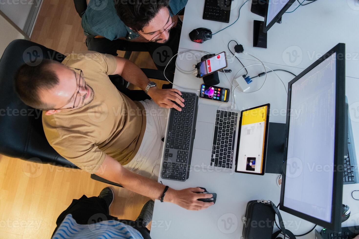 Top view of programmer diligently testing smartphone applications while sitting in their office. photo