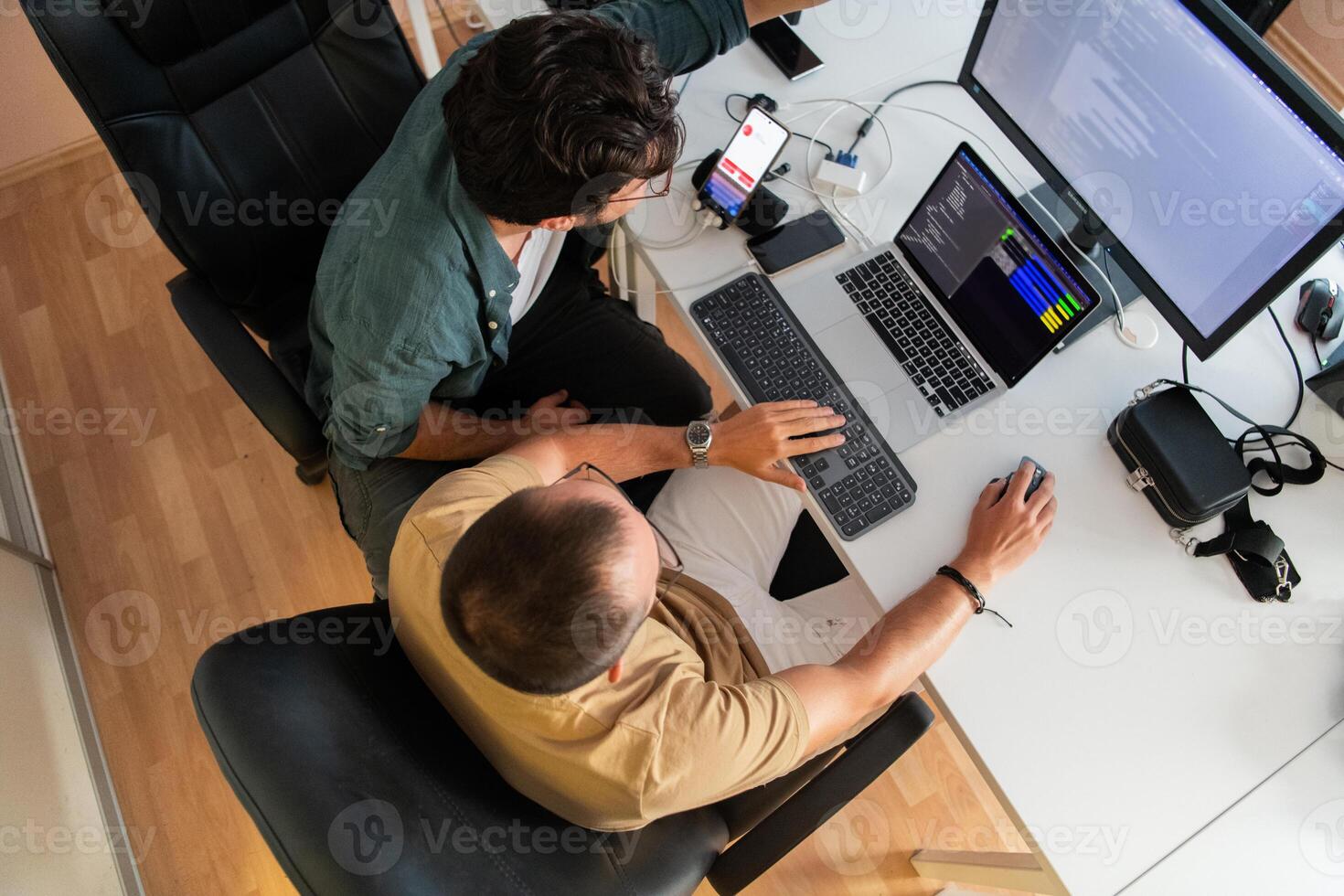 Top view of programmer diligently testing smartphone applications while sitting in their office. photo