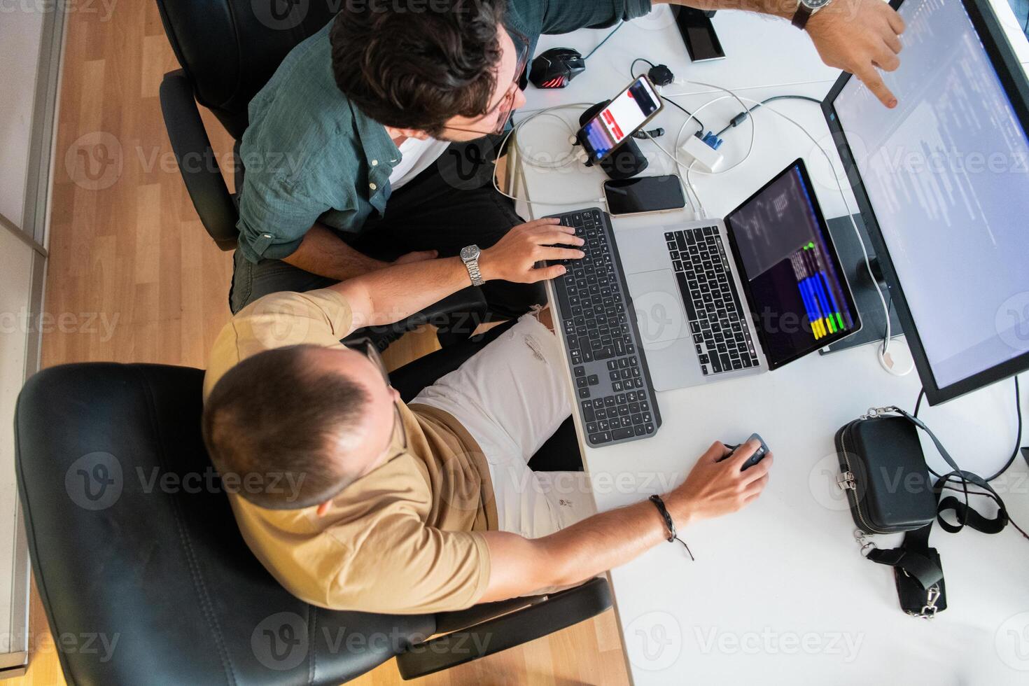 Top view of programmer diligently testing smartphone applications while sitting in their office. photo