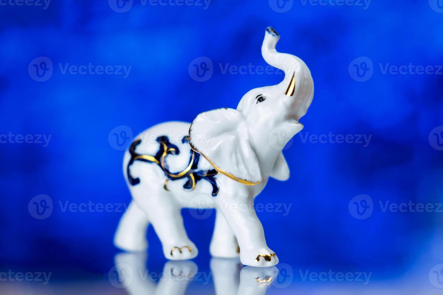 porcelain statuette, porcelain statuette of the elephant on a blue background photo