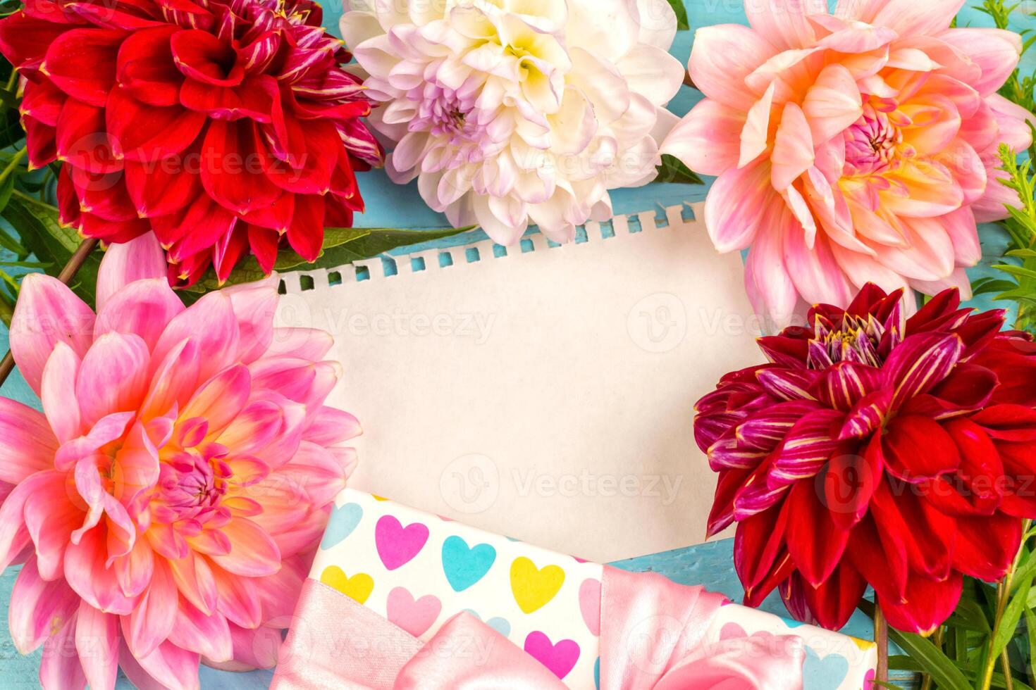 summer background. dahlias and a canvas on a blue wooden background. art. space for a text photo