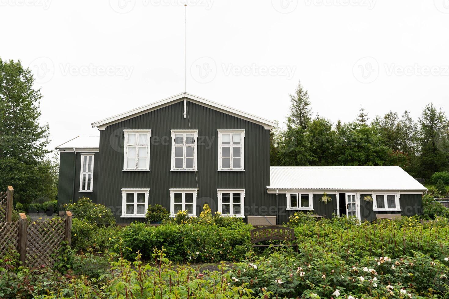 Wooden house amidst a flowering garden front view photo