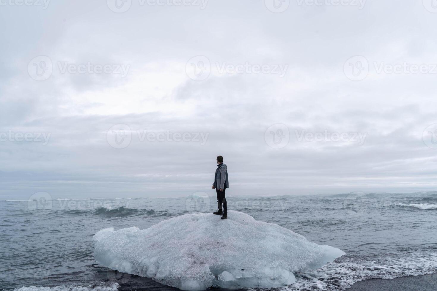 Man Standing on a Floating Iceberg in the Ocean photo