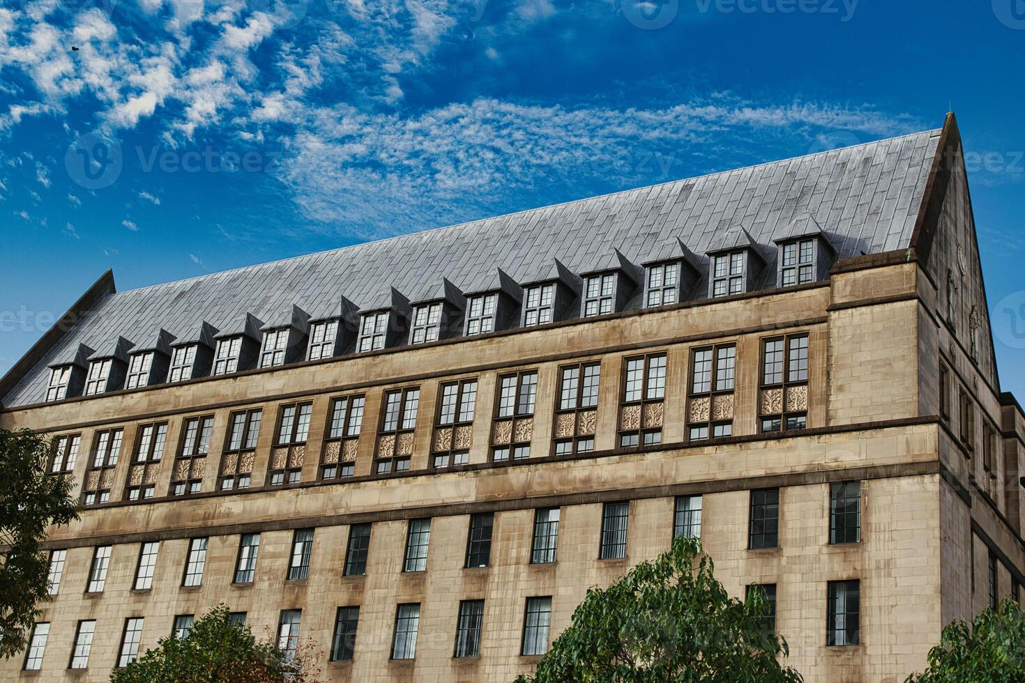 Beige Building with Many Windows and a Dark Gray Roof photo
