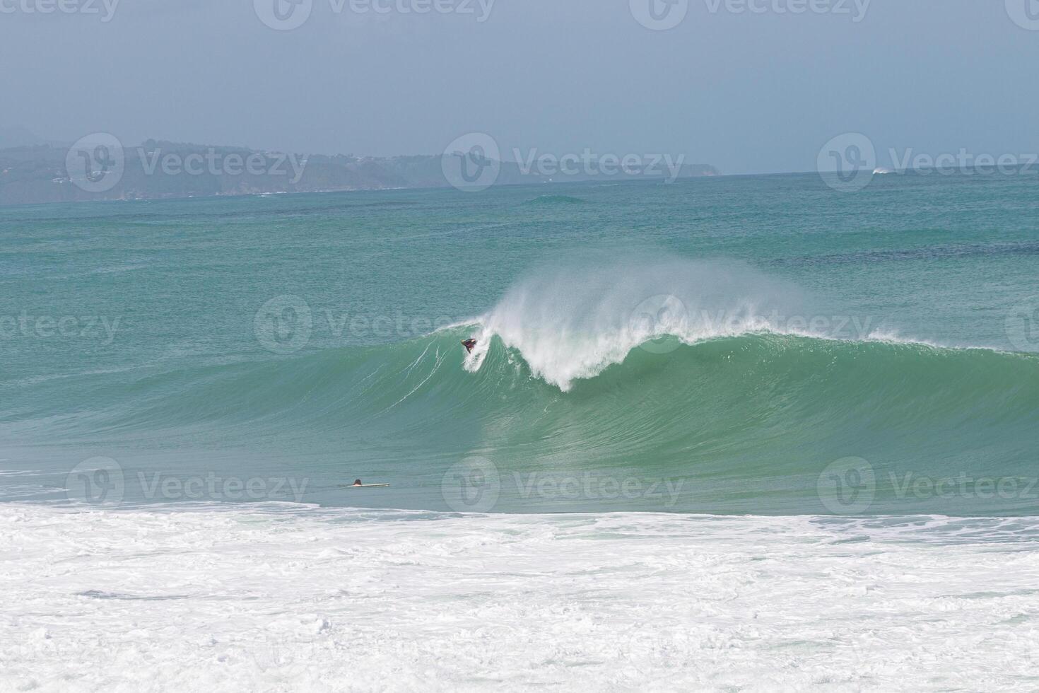 Surfer taking off in a big A-frame wave at VVF, Anse l'etang, tartane, Martinique, West Indies, France photo