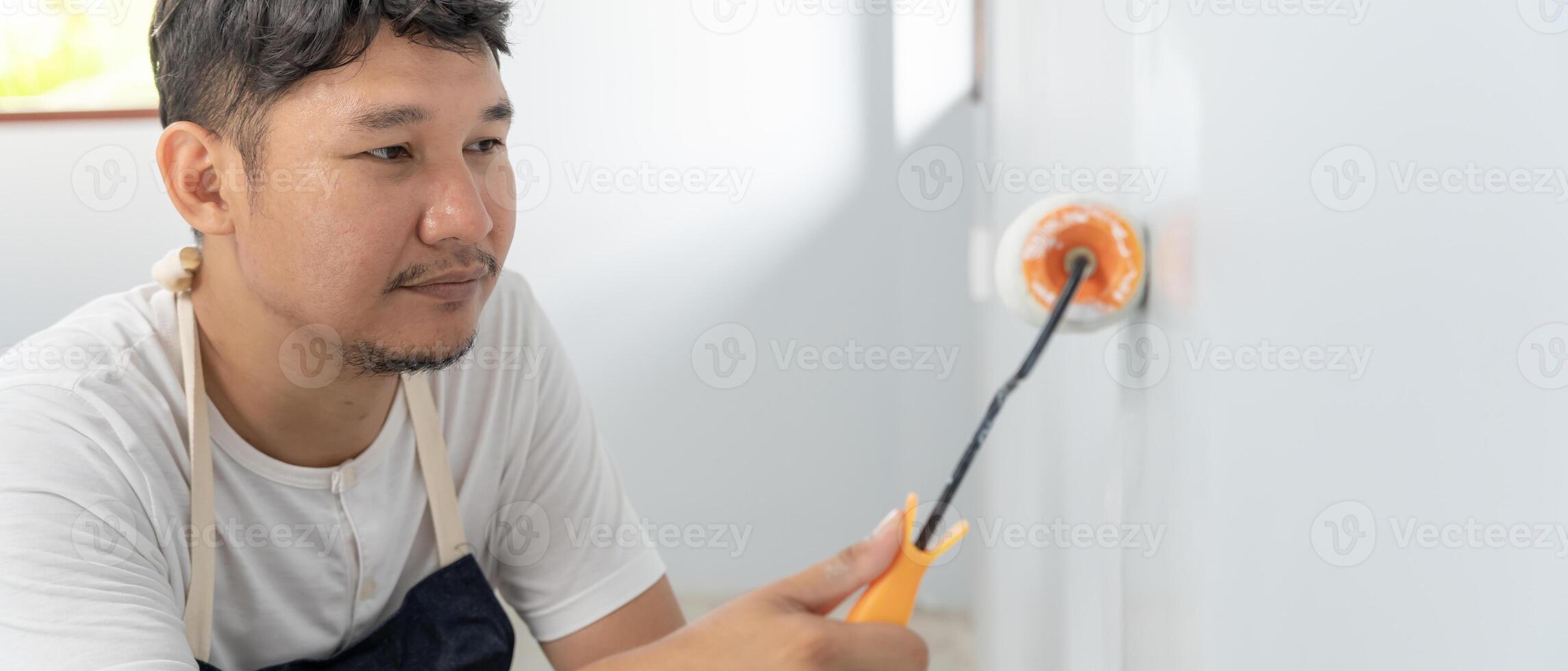 painter man, brush in hand for products to restore and paint the wall, indoor the building site of a house, wall during painting, renovation, painting, contractor, Architect, construction worker photo