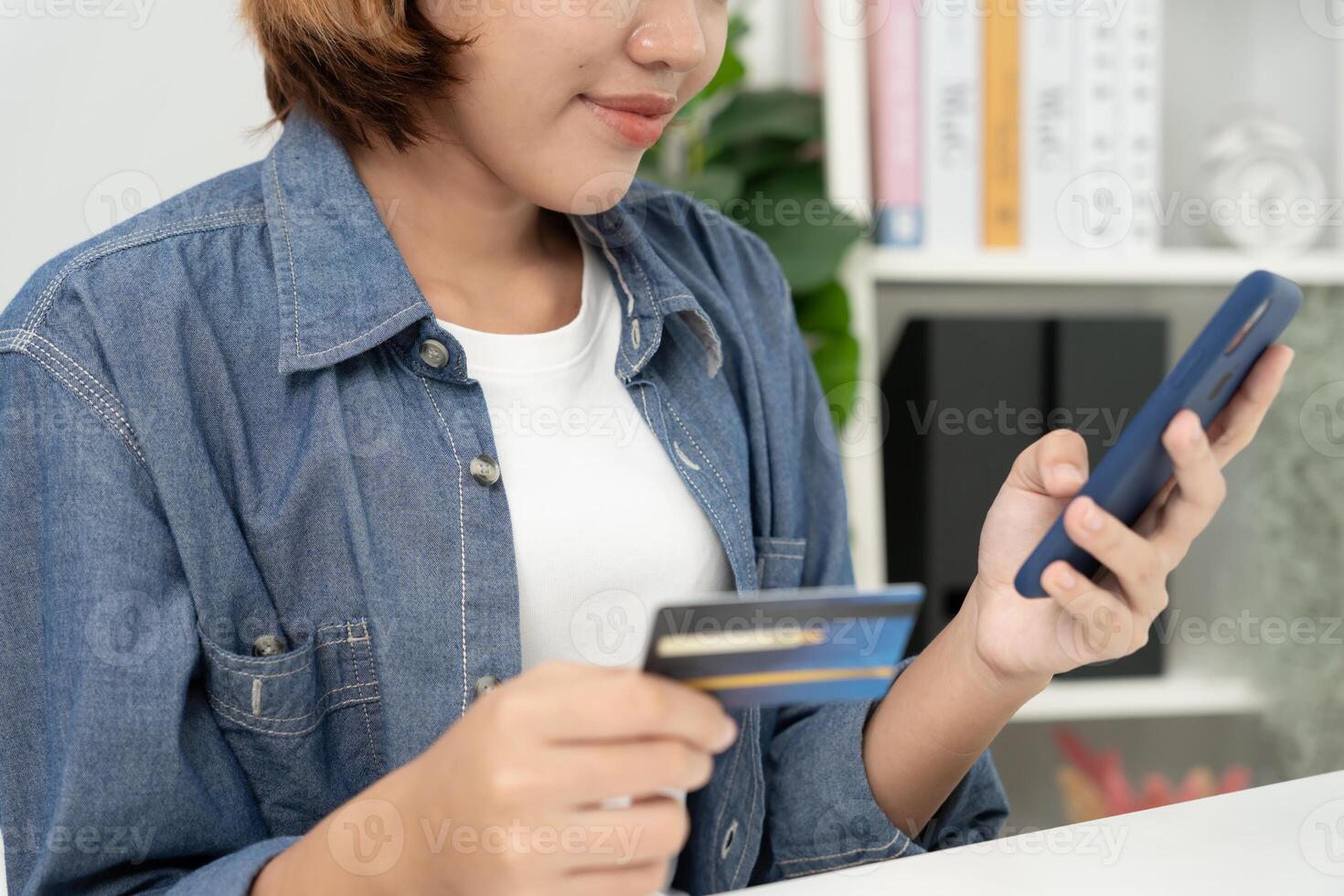 woman using smartphone for online shopping at home. Hand holding mobile phone with payment detail page display and credit card, stay home, technology, electronic commerce, internet, market place photo