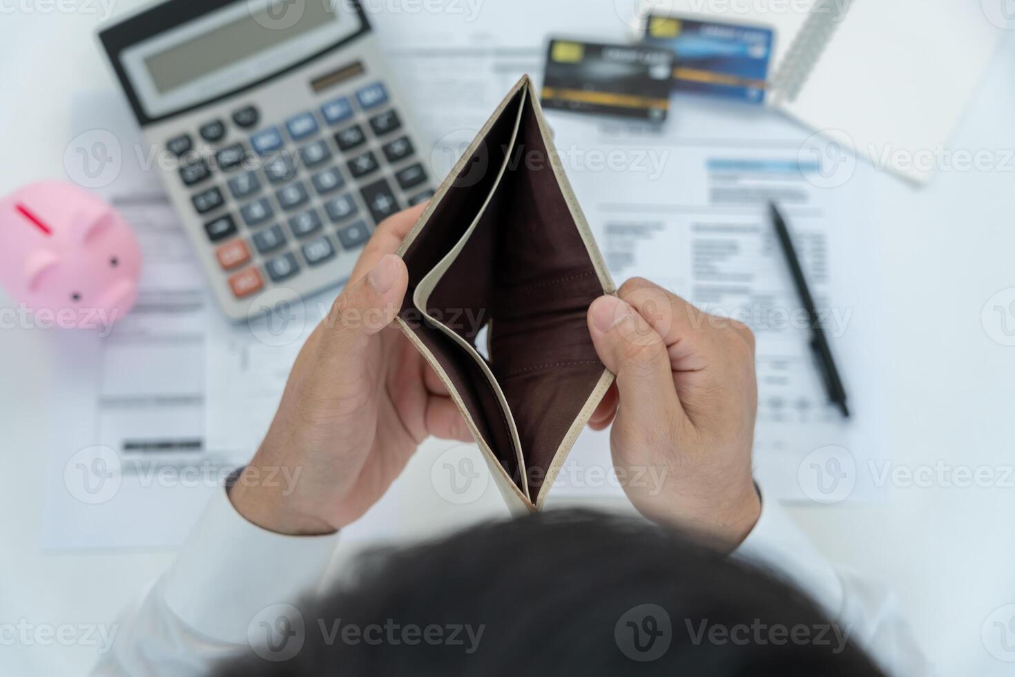 Stressed and headache man with large bills or invoices no money to pay to expenses and credit card debt. shortage, Financial problem, bankruptcy, mortgage, loan, bankrupt, poor, empty wallet photo