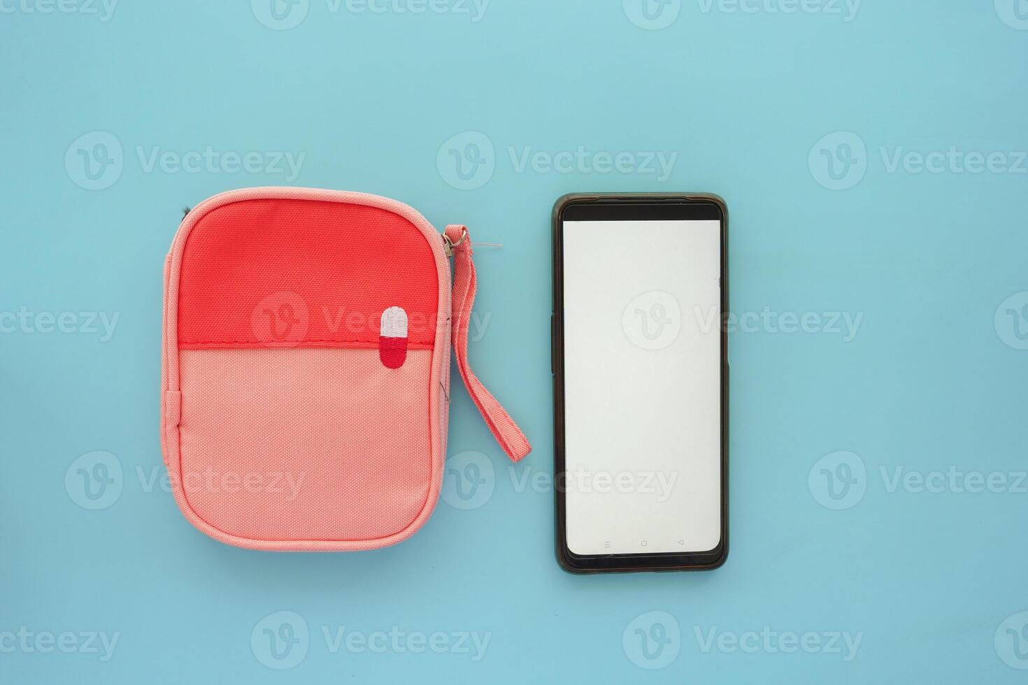 A smartphone alongside a stylish accessory case beautifully arranged on a light blue background photo