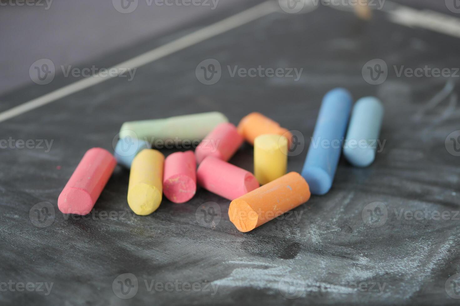 colorful chalk and chalkboard on black background photo
