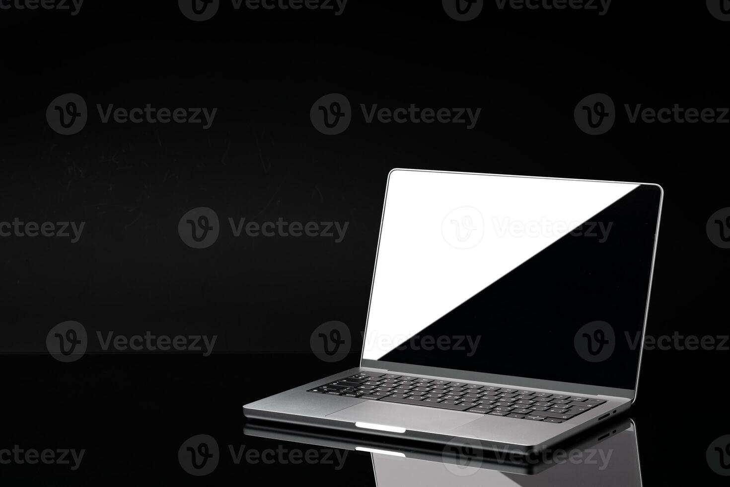 Open laptop with black screen against black background photo