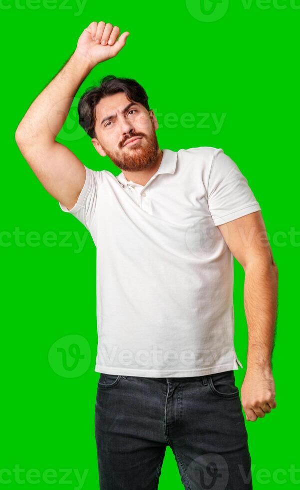 A young man in a white polo shirt dances energetically against a vibrant green background photo