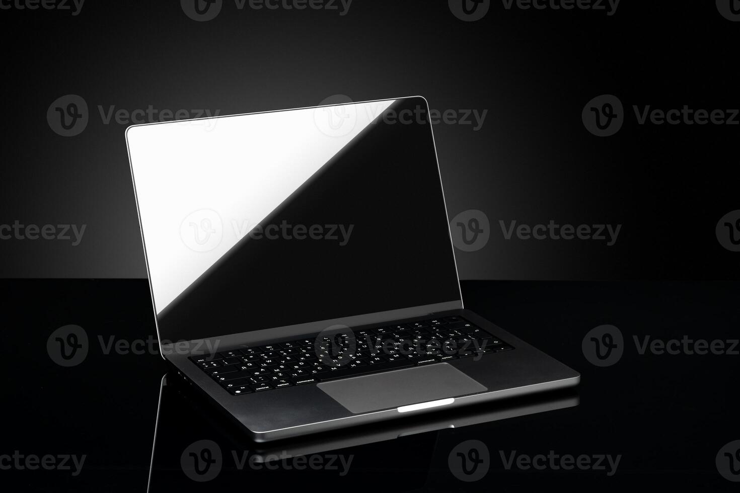 Open laptop with black screen against black background photo