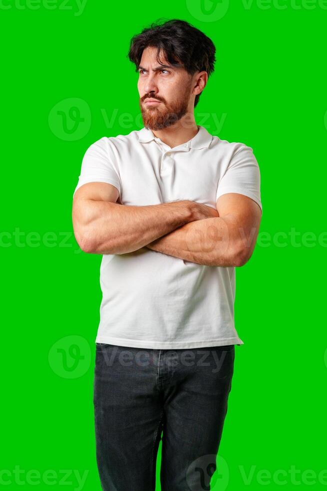 A man with a serious expression stands with crossed arms against a vibrant green background photo