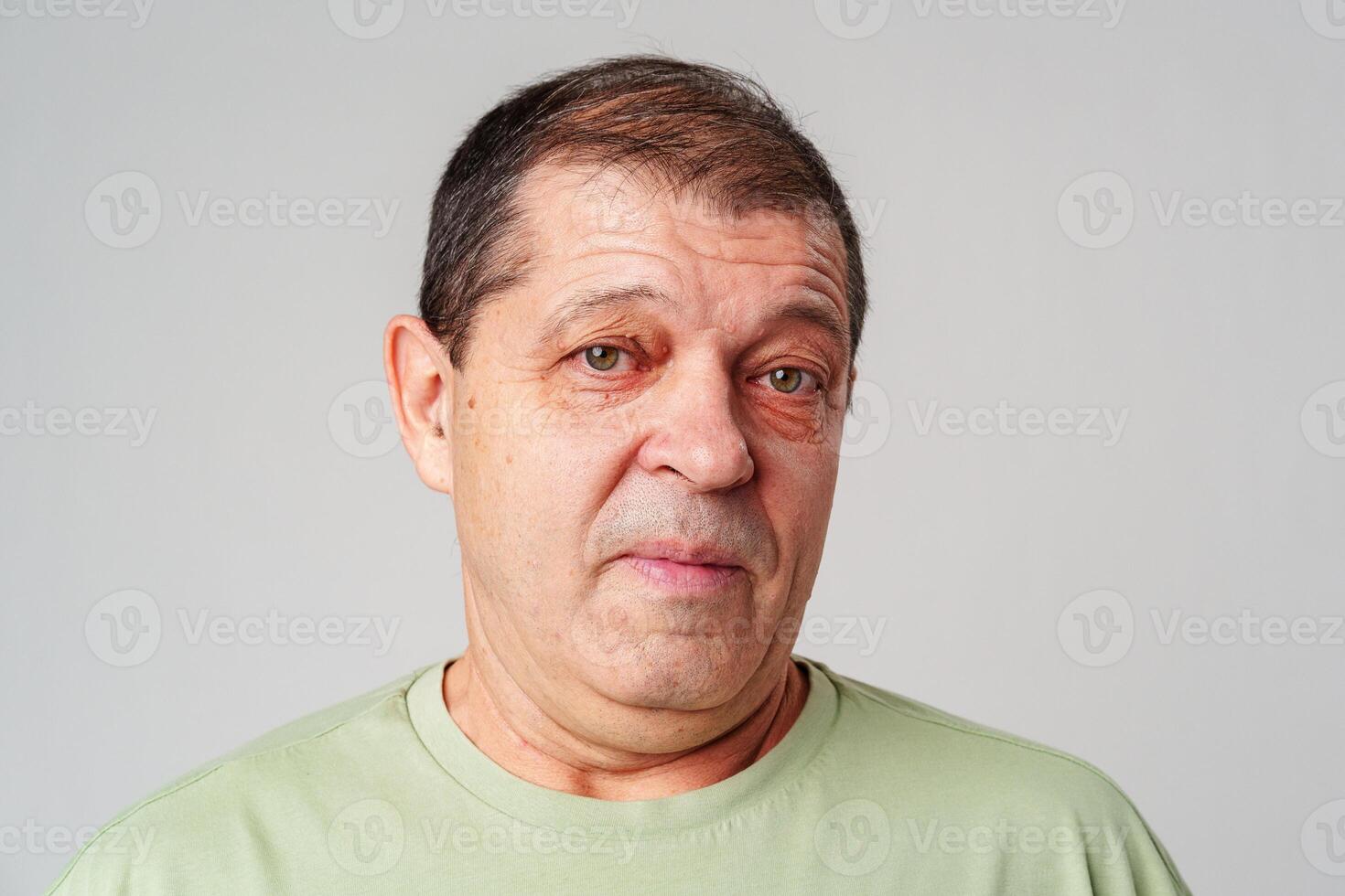 Middle-aged man with a thoughtful expression against a plain background photo