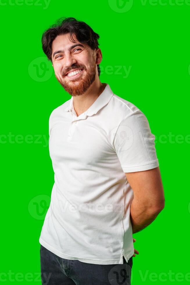 A smiling young man with a beard poses against a bright green background photo