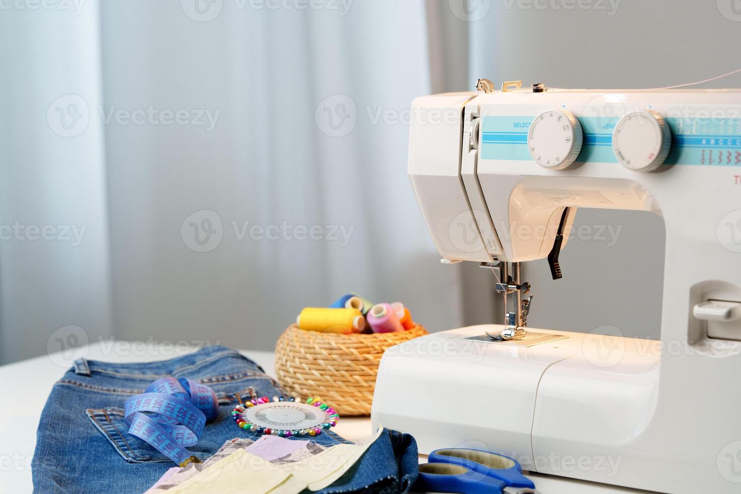 Sewing machine in use on a wooden table, stitching a light fabric in a well-lit indoor workspace photo