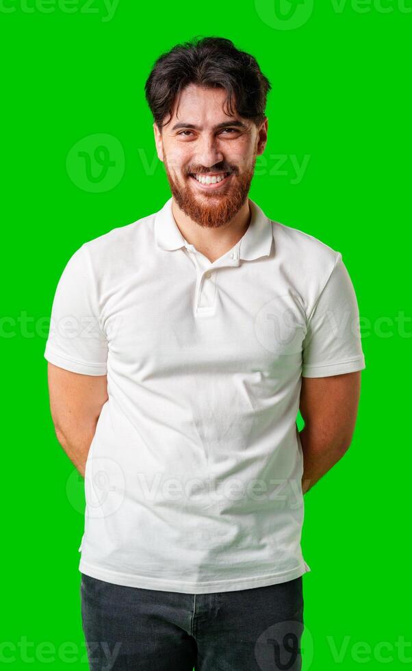 A smiling young man with a beard poses against a bright green background photo