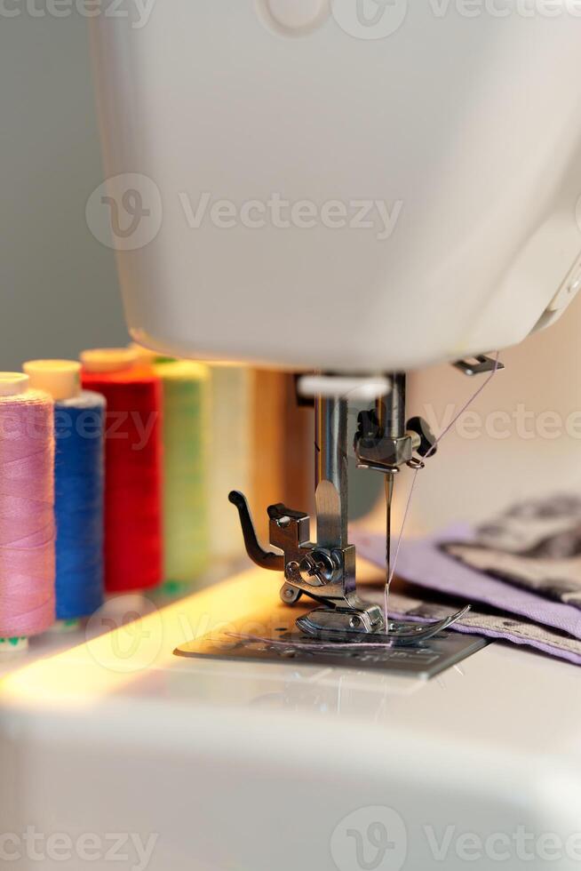 Colorful threads lined up beside a sewing machine ready for creative fabric projects photo