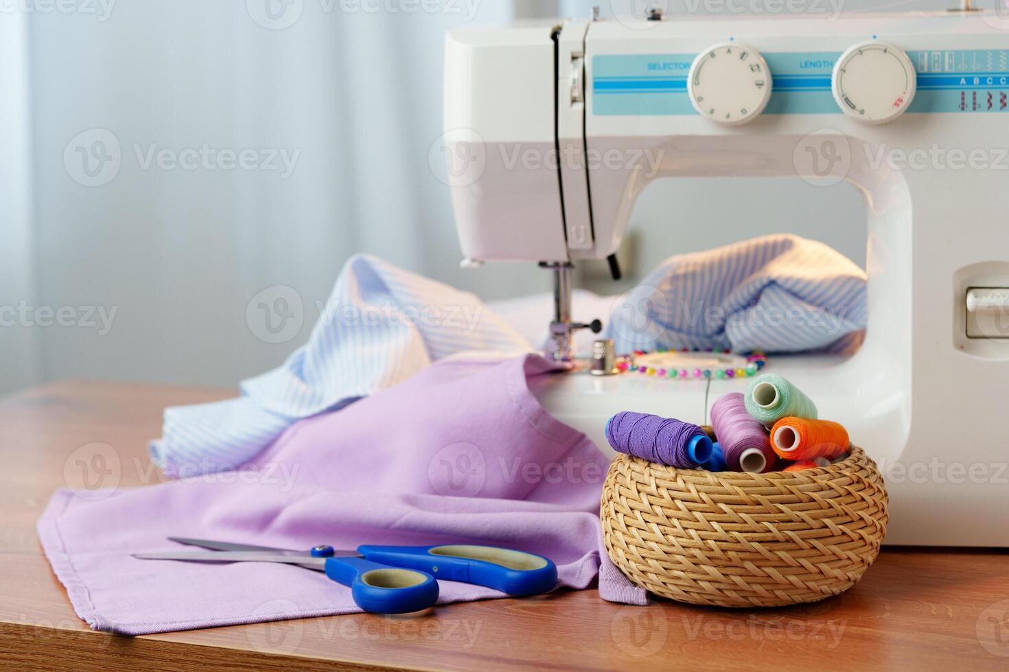 Sewing machine in use on a wooden table, stitching a light fabric in a well-lit indoor workspace photo