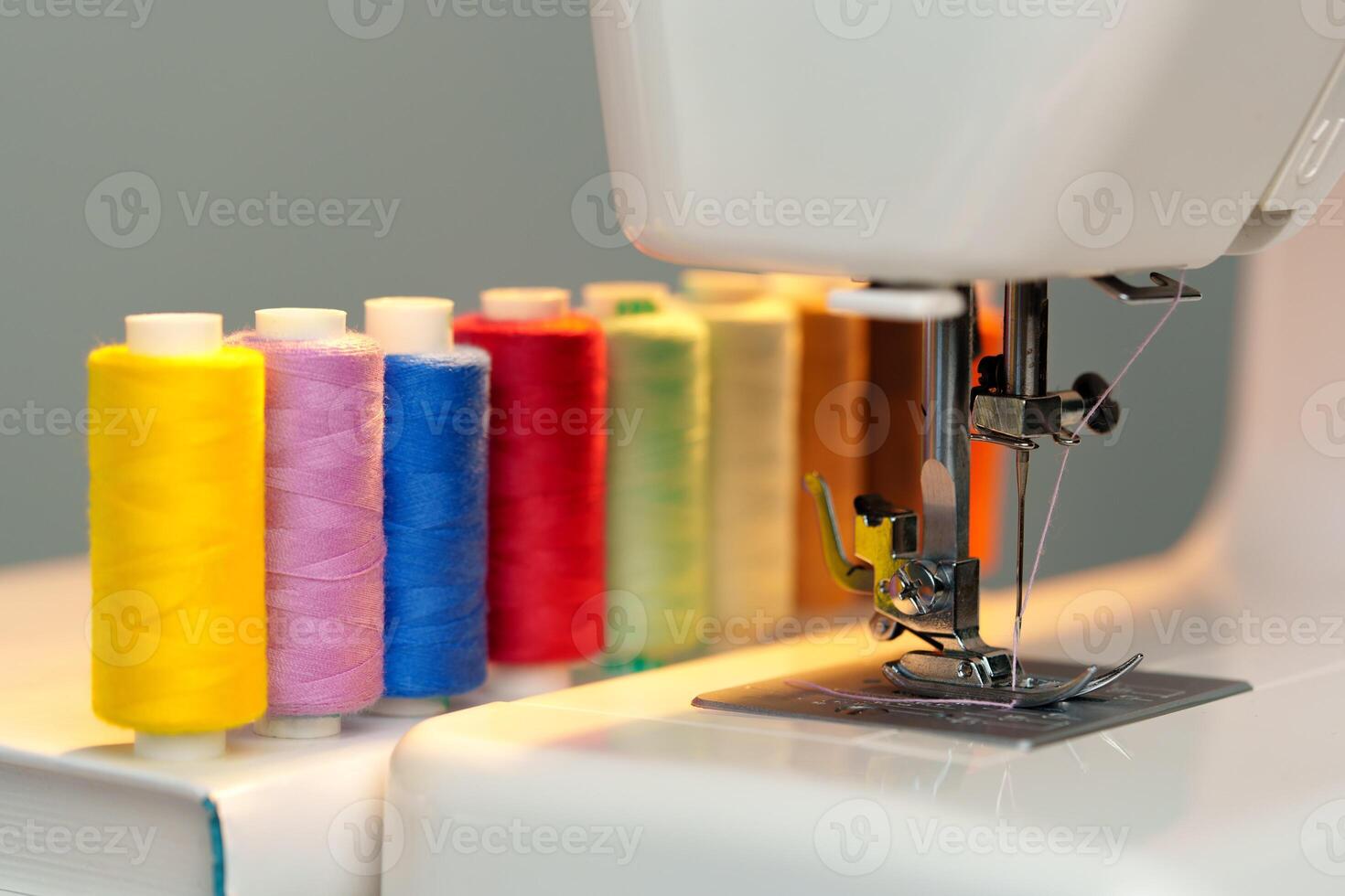 Colorful threads lined up beside a sewing machine ready for creative fabric projects photo