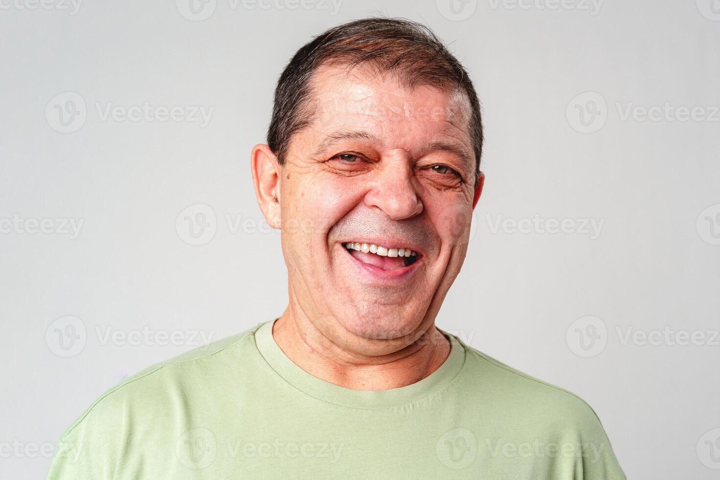 Smiling older man with a warm expression against a neutral background, showcasing happiness and joy photo