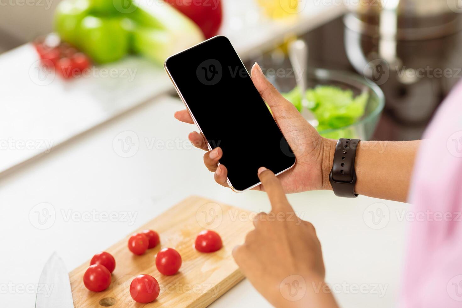 Diet Planning Concept. Female hands using mobile phone on healthy food background, look over shoulder, mock up photo