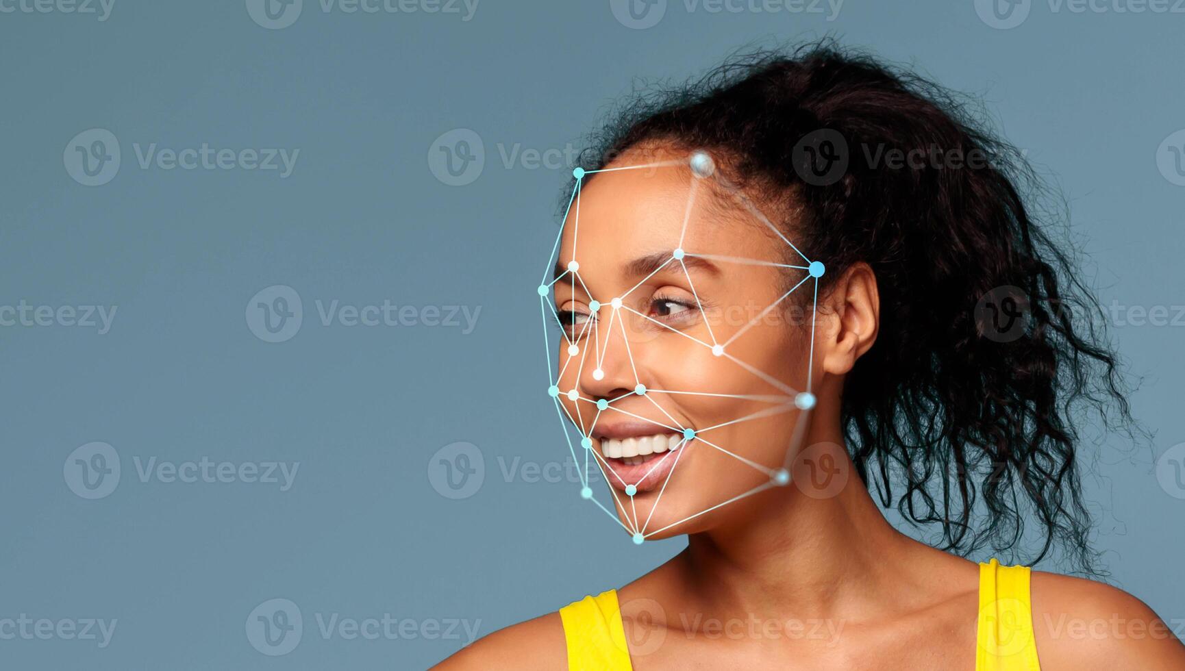 African American woman with curly hair is smiling as facial recognition technology highlights points on her face against a solid background. The setting feels modern and tech-focused. photo