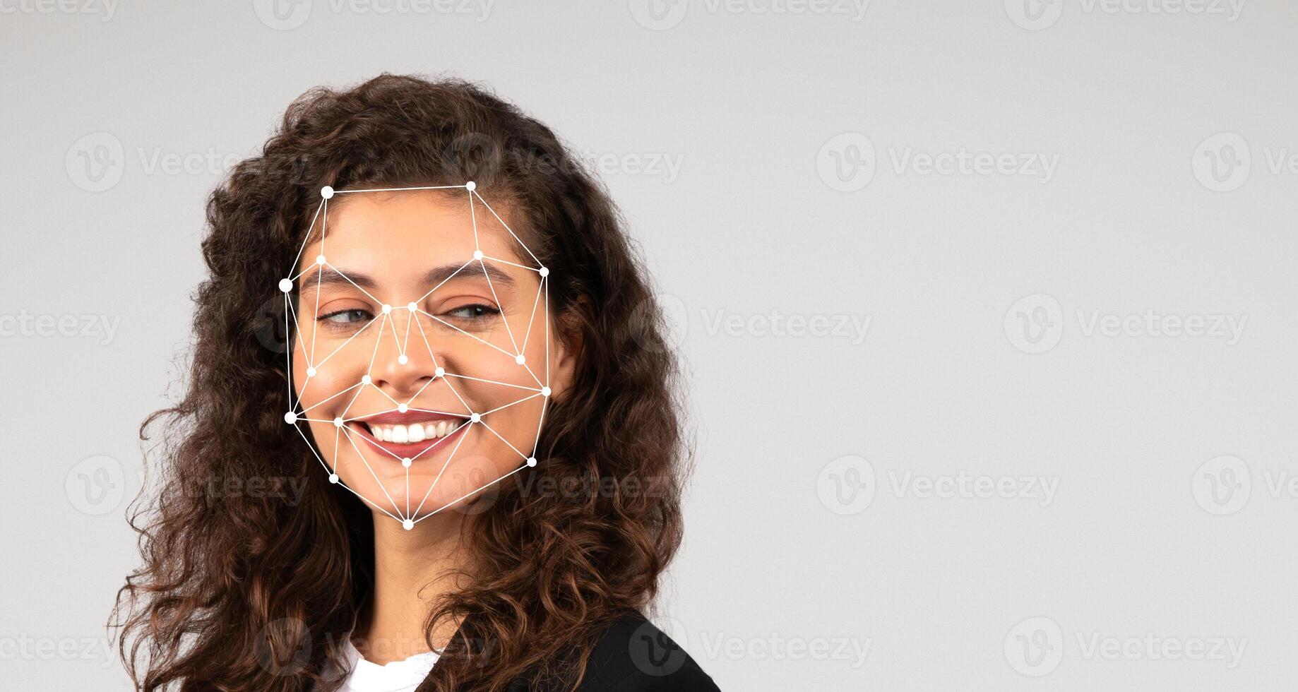 A young woman with curly hair smiles while facial recognition technology is applied, highlighting key facial features through a network of points. She exudes confidence in a simple outfit. photo