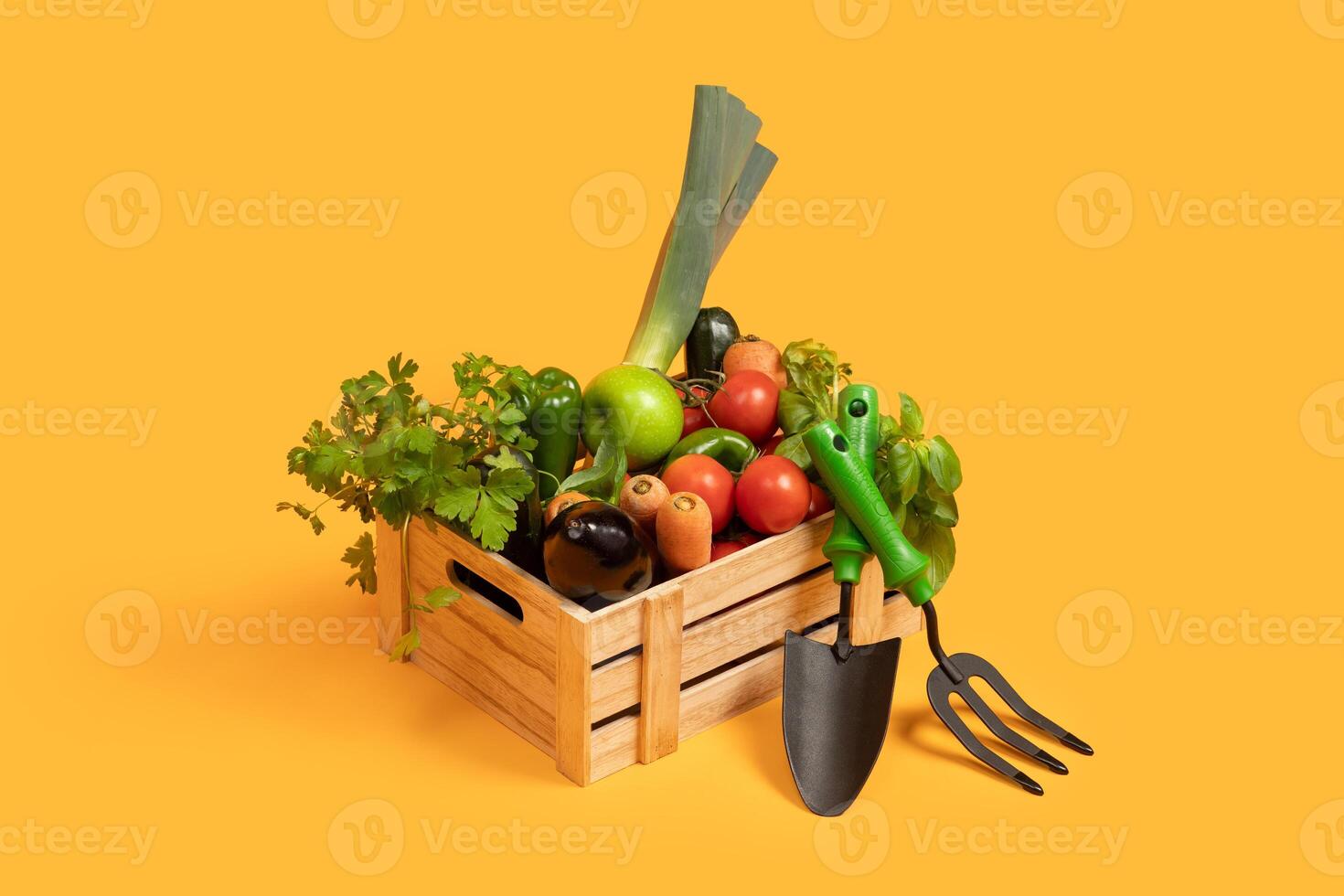 A wooden crate is filled with a variety of fresh vegetables, including tomatoes, green peppers, leeks, and cilantro, resting against a vibrant yellow background. photo