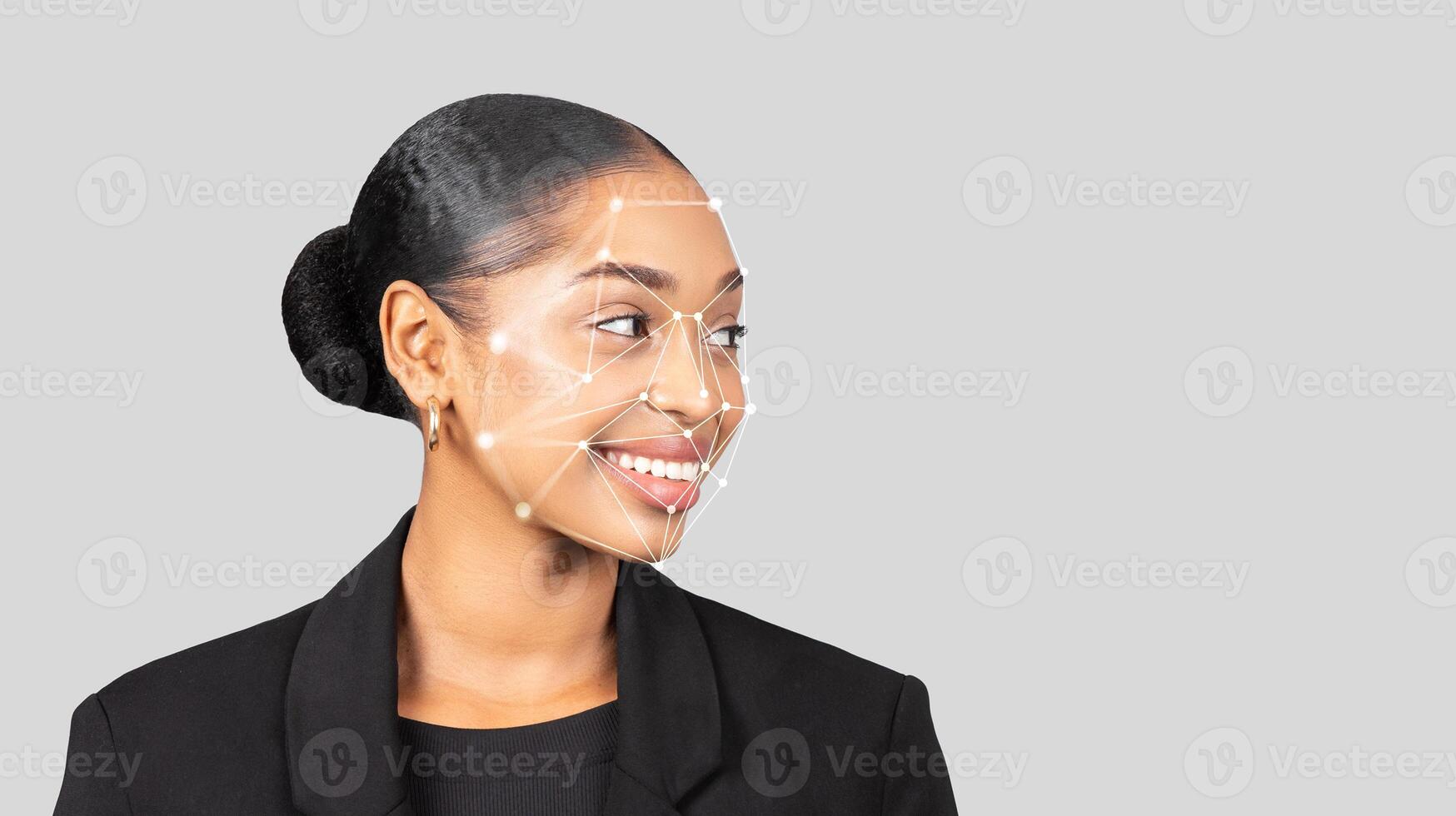 A smiling black woman wears a black blazer, showcasing a digital facial recognition overlay on her profile. The backdrop is a neutral tone, emphasizing her features and the technology displayed. photo