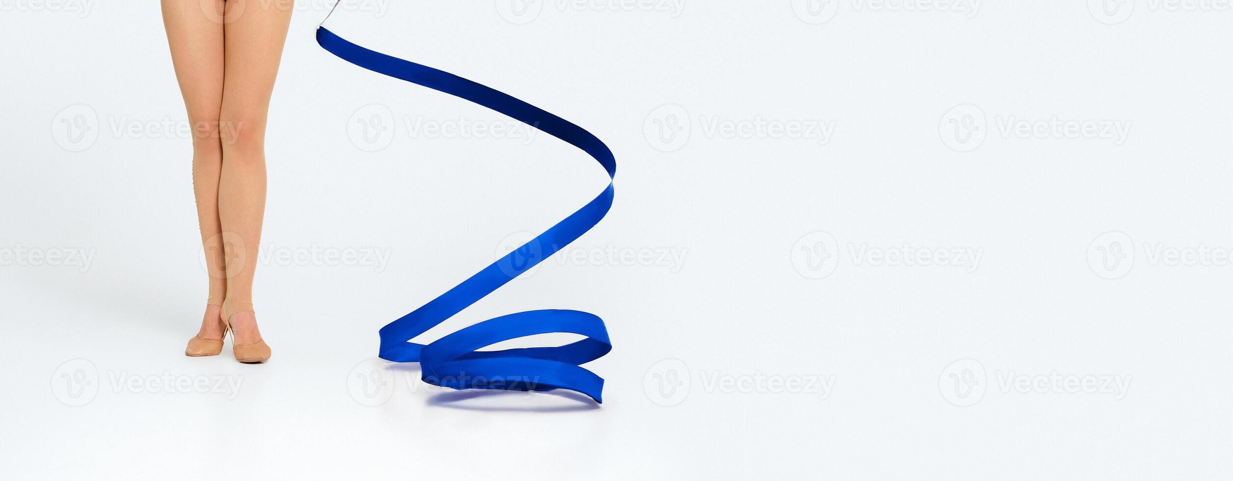 Closeup view of female gymnast's legs and red ribbon on white background, panorama with copy space photo