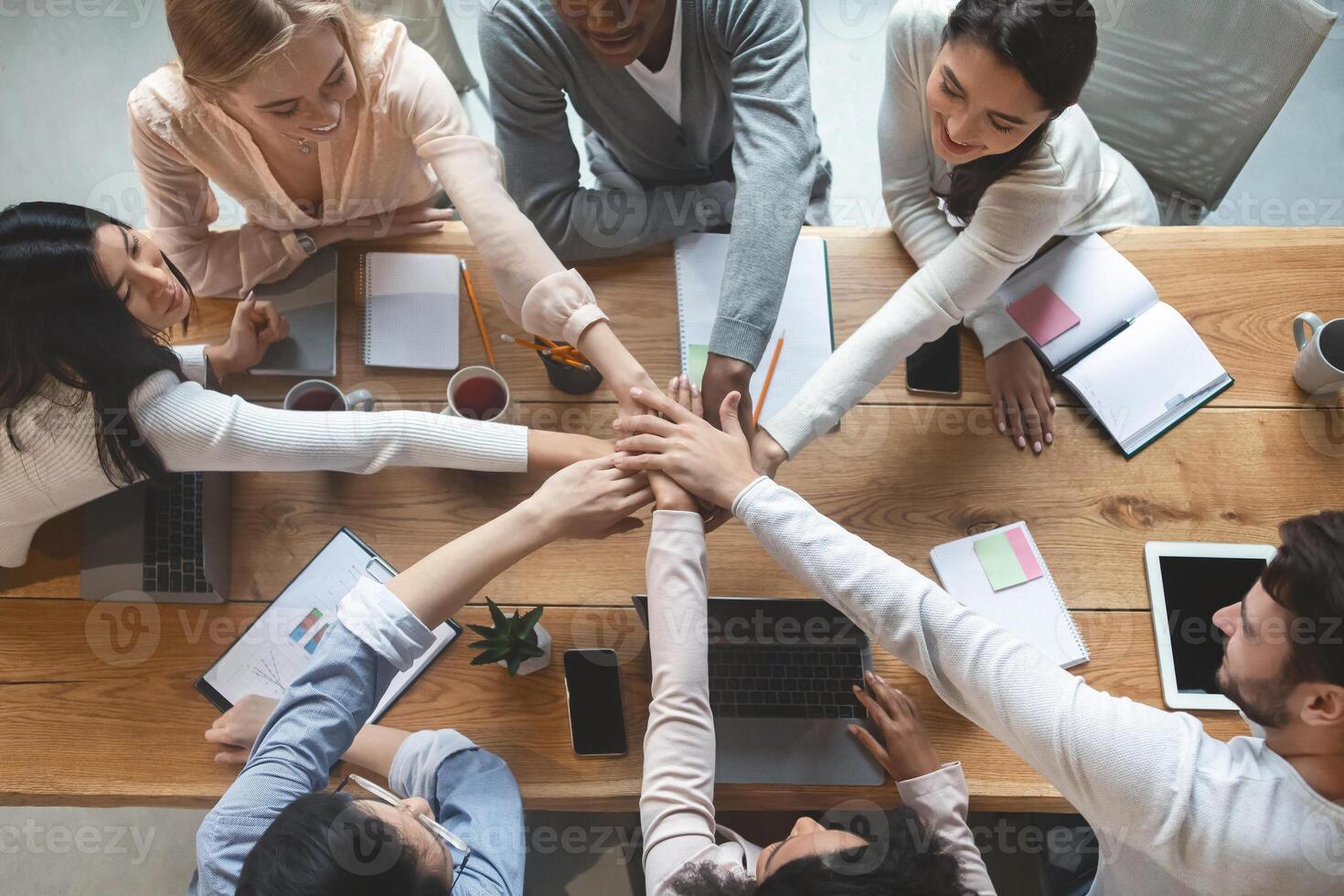 Group of people putting their hands together for united, cooperation and teamwork concept, top view photo