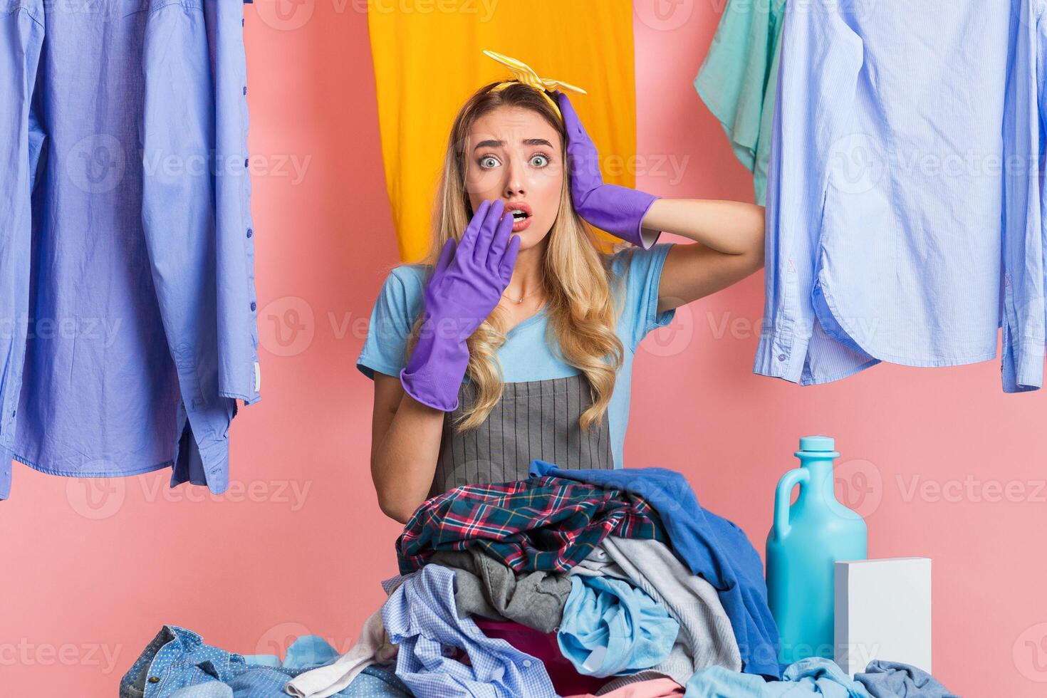 Beautiful shocked housewife in laundry. A lot of work during quarantine photo